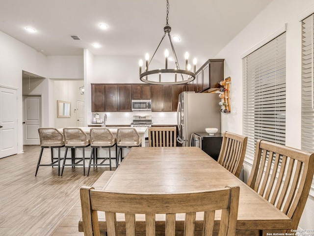dining space with recessed lighting, a notable chandelier, visible vents, and light wood-type flooring