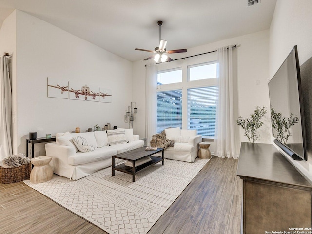 living area featuring visible vents, wood finished floors, and a ceiling fan