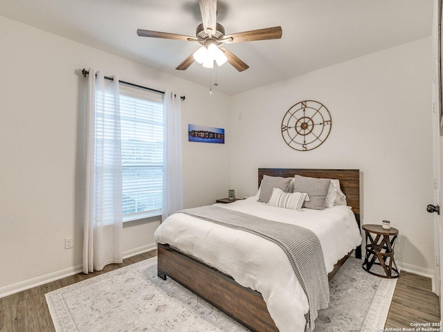 bedroom with baseboards, ceiling fan, and wood finished floors