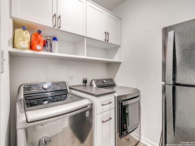 washroom with independent washer and dryer, cabinet space, and wood finished floors