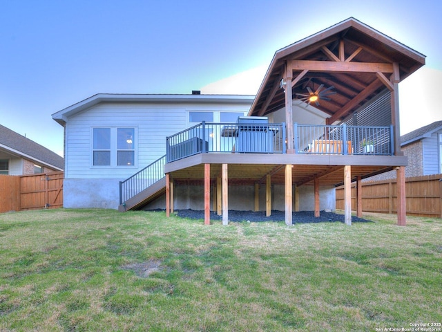 rear view of property featuring a wooden deck, fence, and a yard