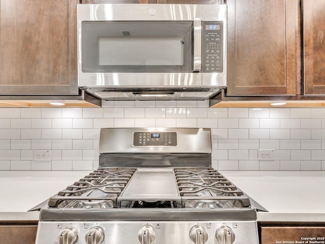 kitchen featuring decorative backsplash, light countertops, and appliances with stainless steel finishes