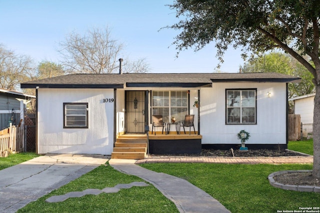 view of front of property with covered porch, a front lawn, and fence