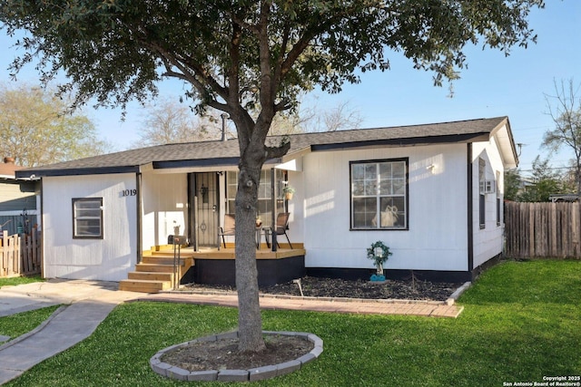 view of front of house featuring covered porch, a front yard, and fence