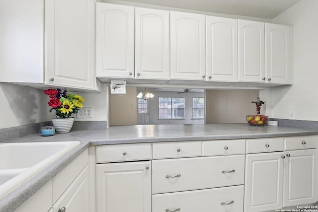 kitchen featuring white cabinetry, light countertops, and a sink