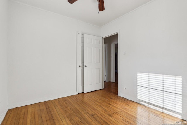 spare room featuring light wood-type flooring, baseboards, ornamental molding, and a ceiling fan