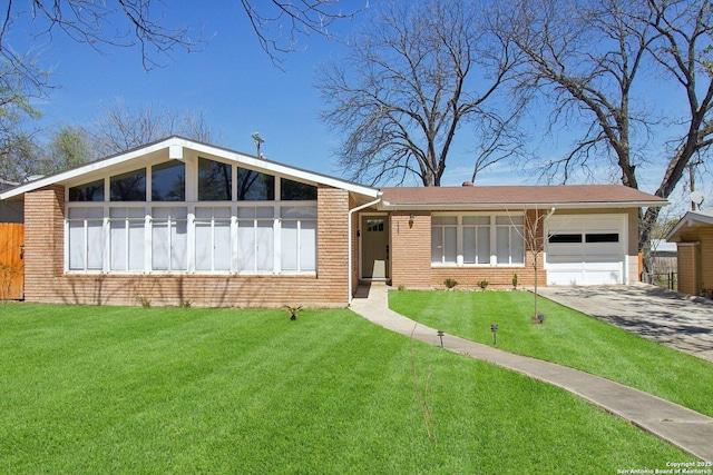 view of front of house featuring driveway, brick siding, an attached garage, and a front lawn
