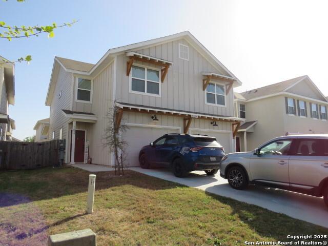 10314 Candlewood Way, San Antonio, TX 78245 - view of front of home featuring board and batten siding, a garage, driveway, and a front yard