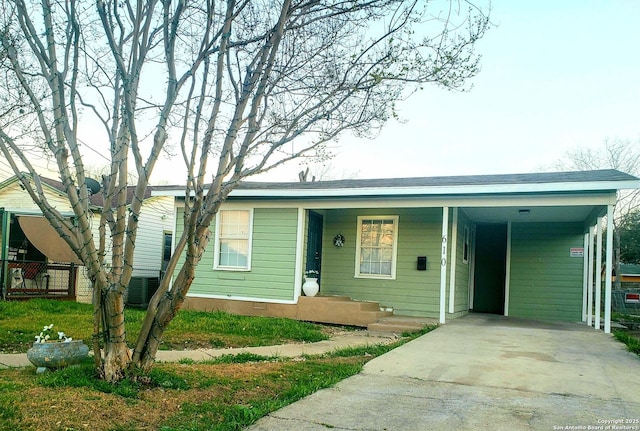 view of front of house featuring concrete driveway and a carport