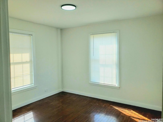 unfurnished room featuring dark wood finished floors and baseboards
