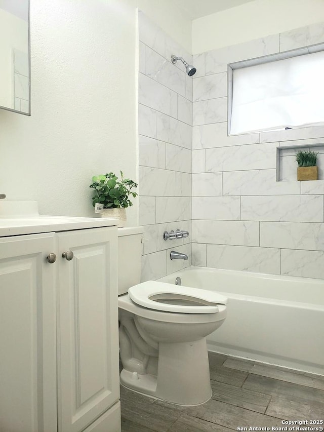 bathroom with tub / shower combination, toilet, and vanity