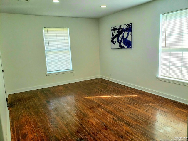 spare room featuring recessed lighting, baseboards, and dark wood-type flooring