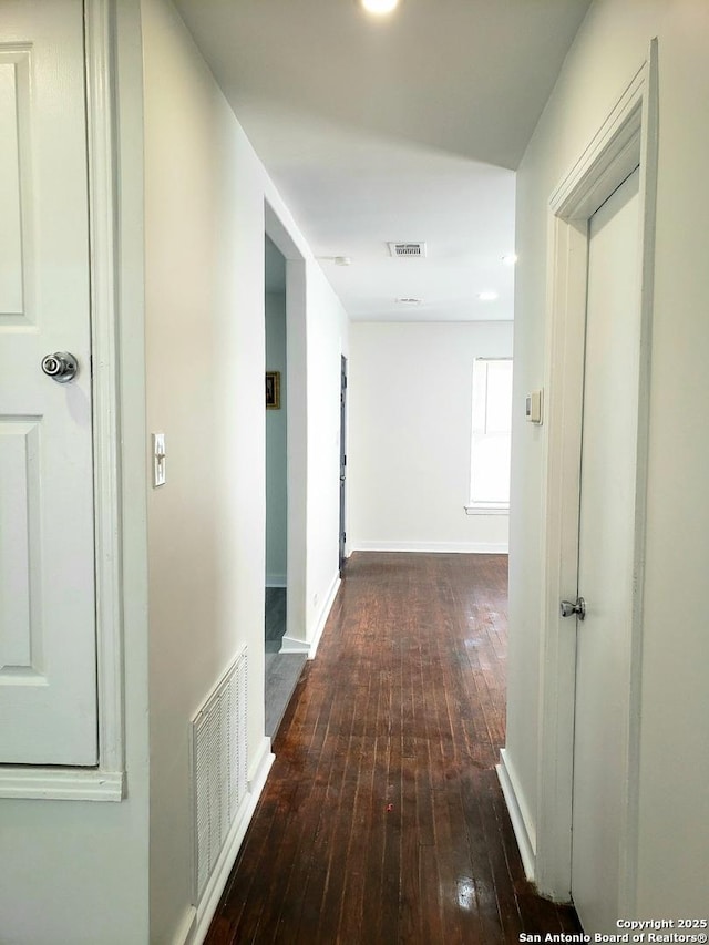 corridor with hardwood / wood-style flooring, baseboards, and visible vents