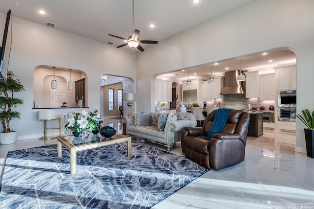 21335 Rembrandt, San Antonio, TX 78256 - living room with a ceiling fan, visible vents, arched walkways, a towering ceiling, and marble finish floor