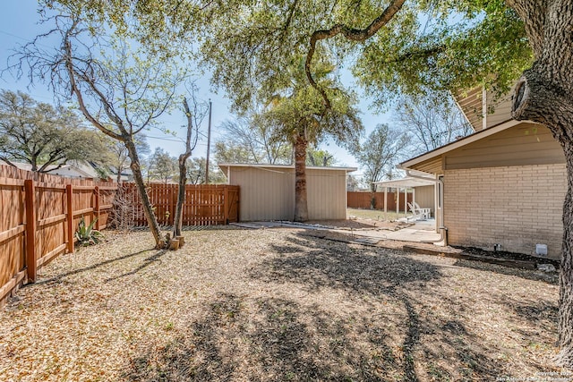 view of yard with a fenced backyard and an outbuilding