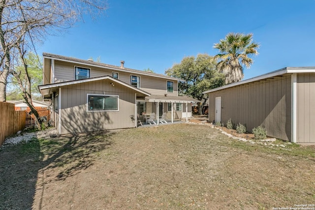 rear view of house featuring a patio and fence