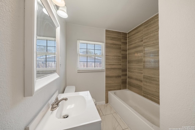 bathroom with toilet, marble finish floor, a washtub, walk in shower, and vanity