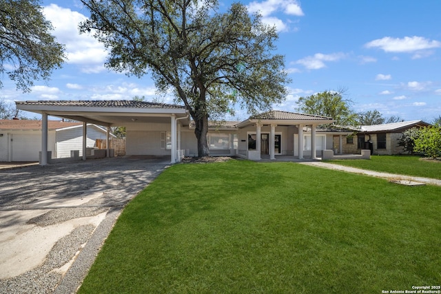 view of front of home featuring an attached carport, a front lawn, and driveway