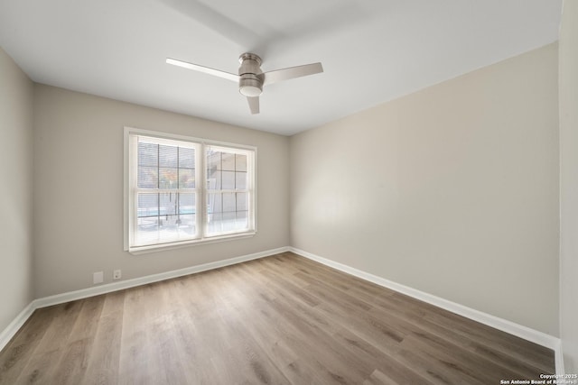 spare room with ceiling fan, baseboards, and wood finished floors