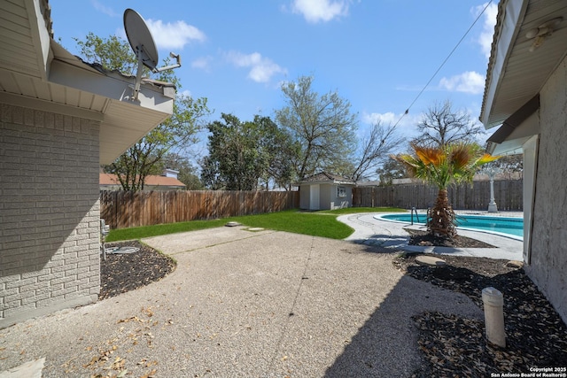 view of yard featuring a patio, an outbuilding, a fenced in pool, a fenced backyard, and a storage unit