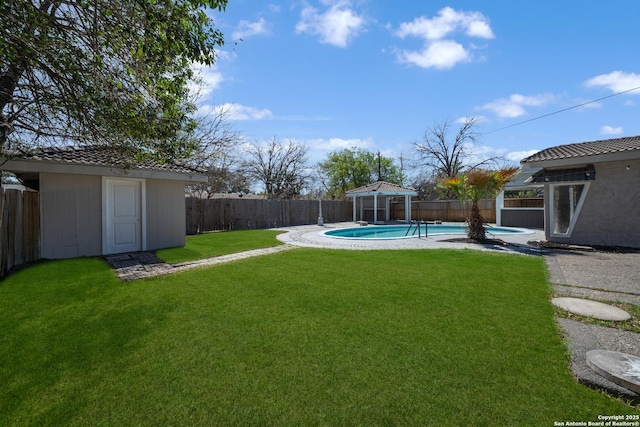 view of yard featuring an outbuilding, a fenced in pool, a storage shed, and a fenced backyard