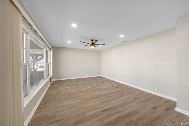 unfurnished room featuring visible vents, wood finished floors, baseboards, and ceiling fan