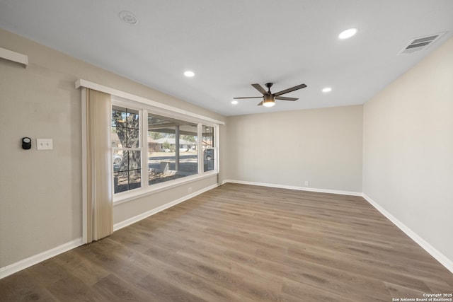 empty room featuring wood finished floors, baseboards, visible vents, recessed lighting, and ceiling fan