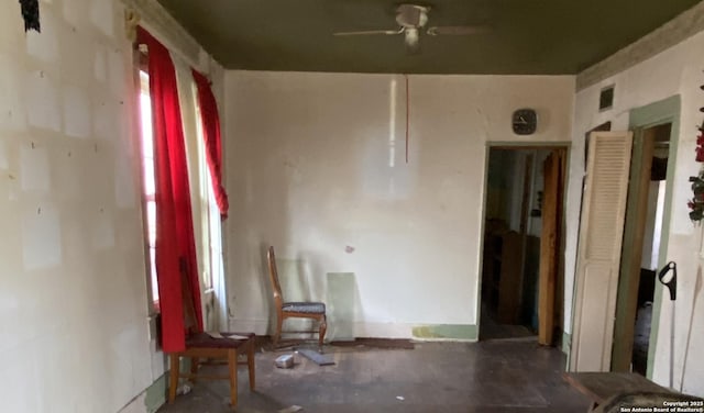 unfurnished room with visible vents, concrete flooring, and ceiling fan