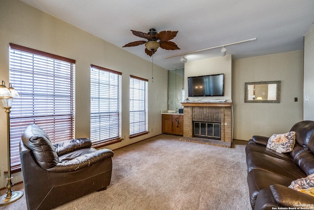 8633 Datapoint Unit 227, San Antonio, TX 78229 - carpeted living area featuring ceiling fan, a brick fireplace, and track lighting
