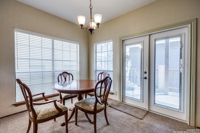 8633 Datapoint Unit 227, San Antonio, TX 78229 - carpeted dining room featuring a textured wall, plenty of natural light, and a chandelier