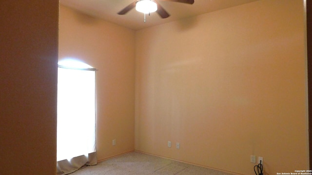 empty room with light colored carpet and a ceiling fan