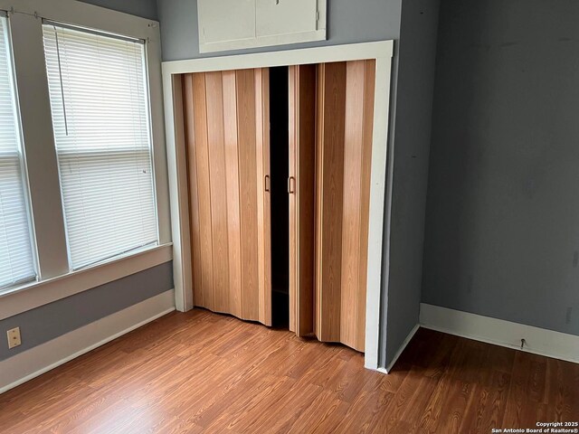 unfurnished bedroom featuring a closet, light wood-style flooring, and baseboards