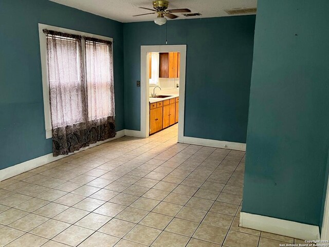 spare room with light tile patterned floors, visible vents, ceiling fan, and a sink