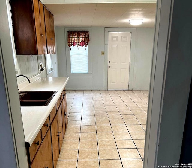 kitchen with light tile patterned floors, light countertops, and a sink