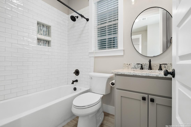 bathroom featuring vanity, wood finished floors, visible vents, shower / bath combination, and toilet
