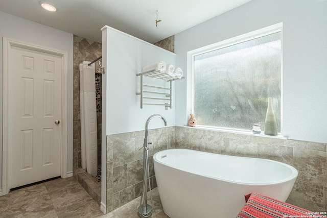 191 Campfire Cir, Fredericksburg, TX 78624 - bathroom featuring a freestanding bath, a tile shower, tile walls, and wainscoting