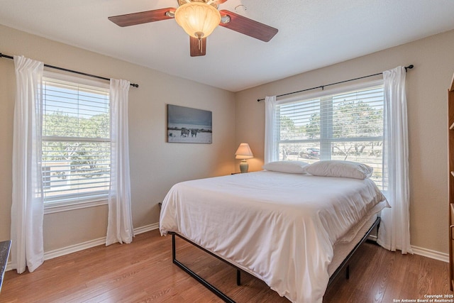 191 Campfire Cir, Fredericksburg, TX 78624 - bedroom with baseboards, light wood-style flooring, and ceiling fan