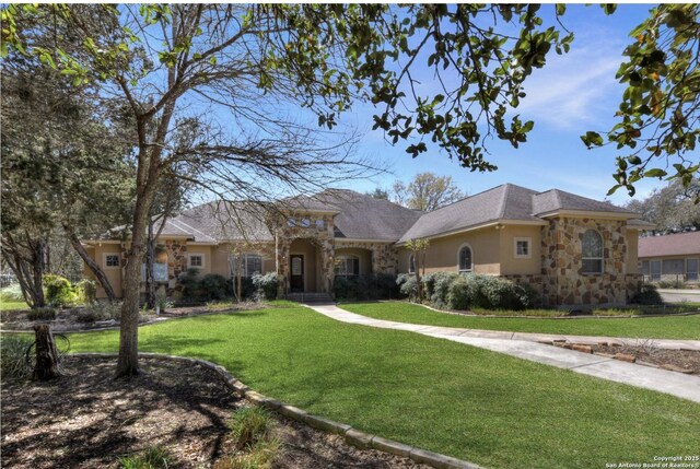 view of front of property featuring stone siding, a front yard, and stucco siding