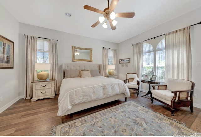 bedroom featuring hardwood / wood-style floors, baseboards, multiple windows, and ceiling fan