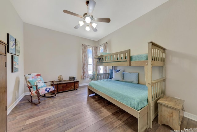 bedroom with a ceiling fan, hardwood / wood-style flooring, and baseboards