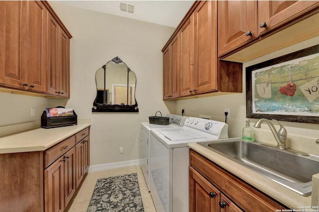 laundry area featuring visible vents, baseboards, cabinet space, a sink, and washing machine and dryer