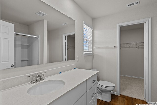 819 Bluegrass Pt, New Braunfels, TX 78130 - full bath with visible vents, a shower stall, toilet, vanity, and a walk in closet