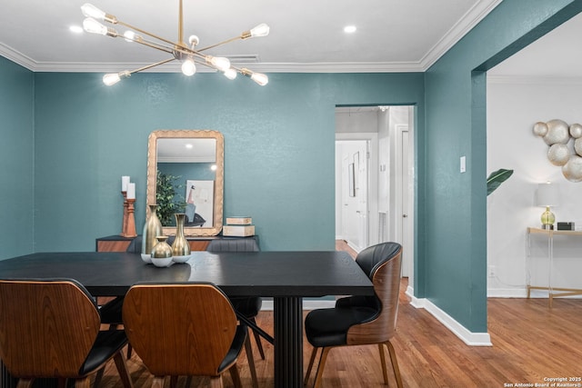dining area with crown molding, baseboards, an inviting chandelier, and wood finished floors