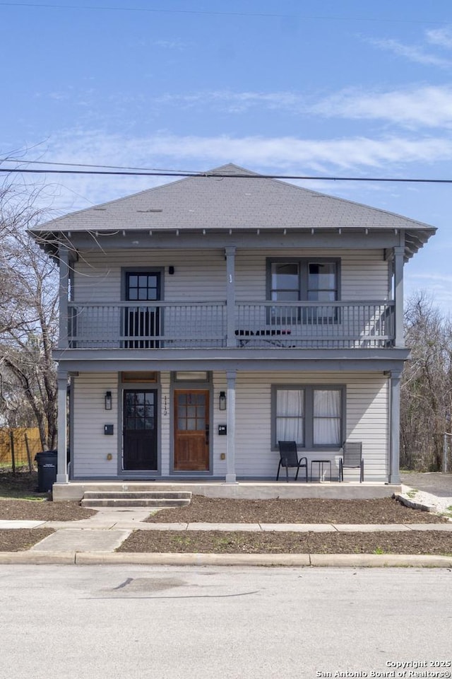 view of front of home with a balcony, a shingled roof, and a porch