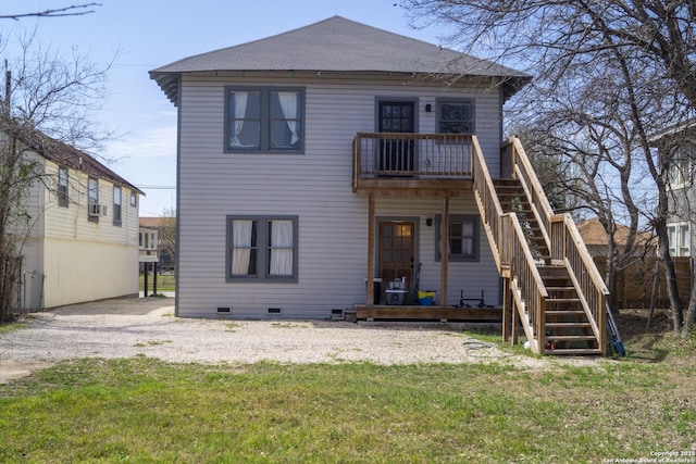 back of house featuring crawl space, stairs, and a yard