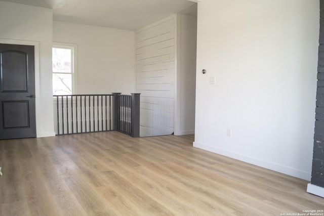 empty room with baseboards and wood finished floors