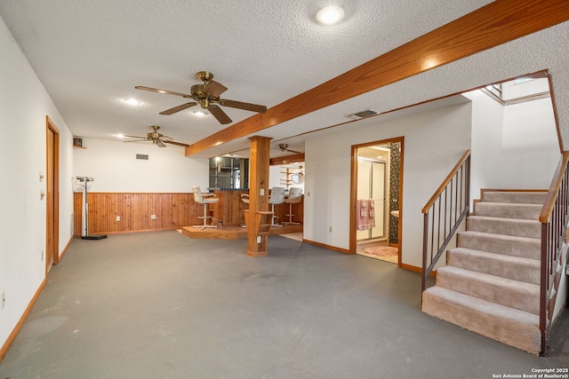 831 Hill Top, Canyon Lake, TX 78133 - unfurnished living room with stairs, bar, finished concrete floors, a textured ceiling, and visible vents