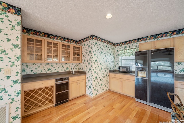 831 Hill Top, Canyon Lake, TX 78133 - kitchen with a textured ceiling, wallpapered walls, dark countertops, visible vents, and black appliances