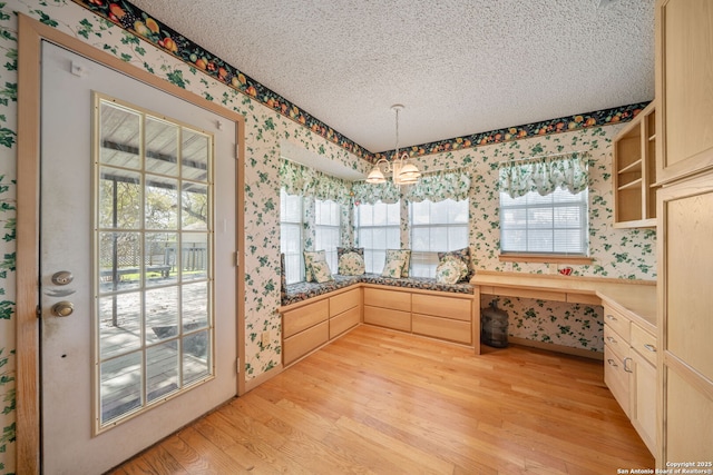 831 Hill Top, Canyon Lake, TX 78133 - interior space with a textured ceiling, wallpapered walls, decorative light fixtures, light wood-style floors, and open shelves