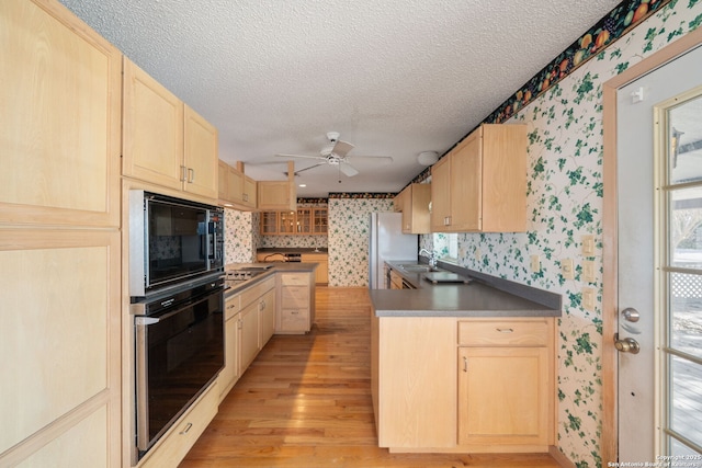 831 Hill Top, Canyon Lake, TX 78133 - kitchen with wallpapered walls, black appliances, and light brown cabinets